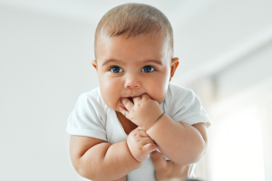 a baby smiling at the camera for rainbow fertility